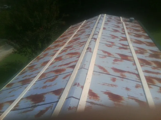 Rusted metal roof panels with new wood purlins before replacement — Storm Damage Roof Repair in Cedar Bluffs by Roofing Brothers