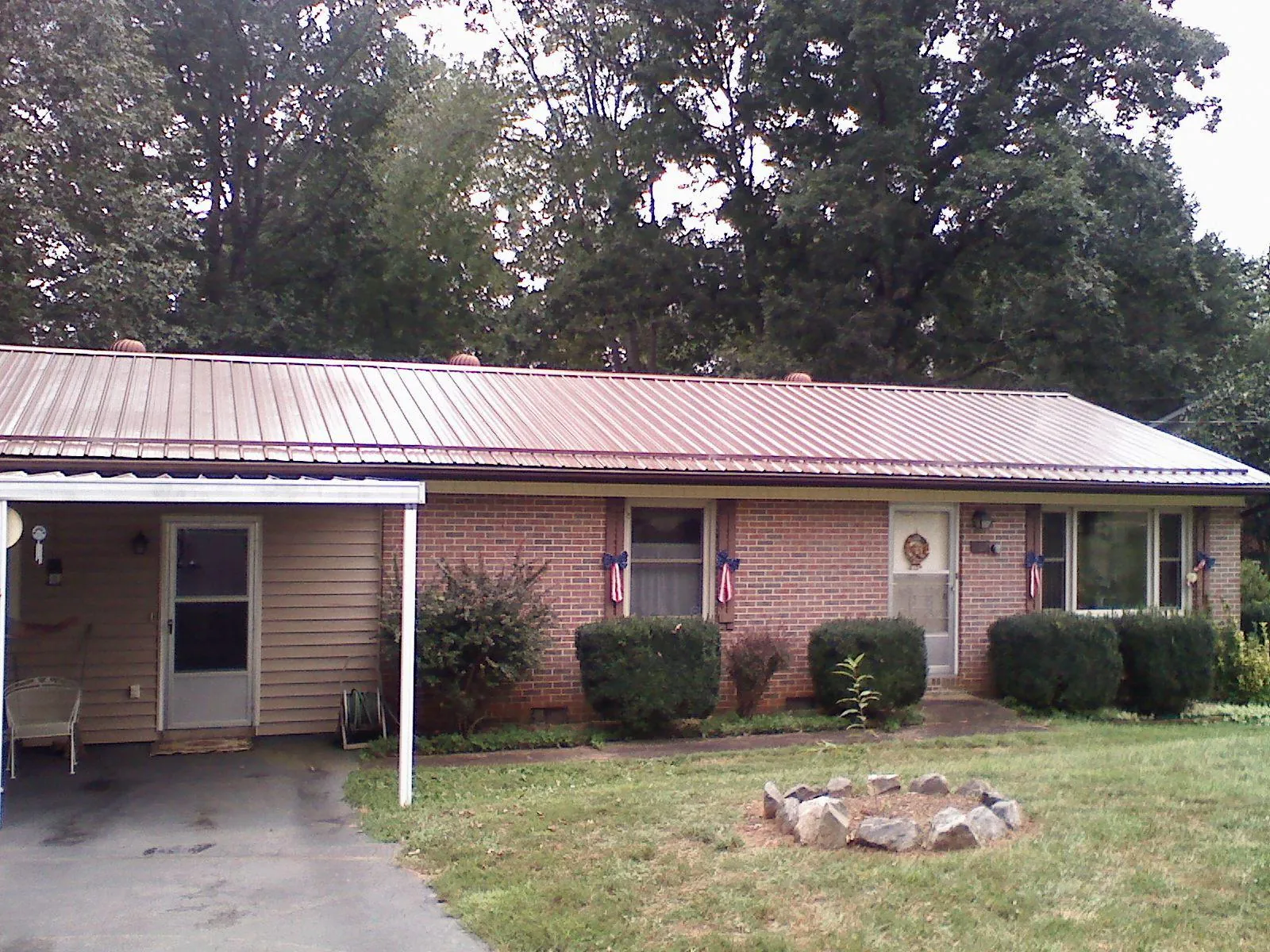 Bronze metal roof and carport on a brick ranch home — Roof Repair work by our crew in Cedar Bluffs