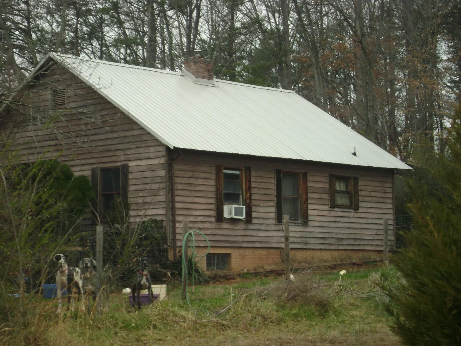 White metal roof on an old wood sided farmhouse, from a Metal Roof Installation job in Cedar Bluffs